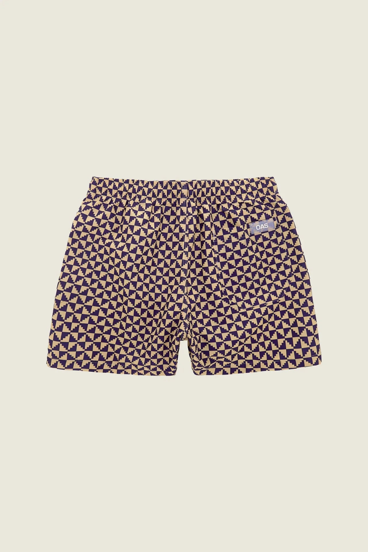 Navy blue and gold patterned shorts on a light green background
