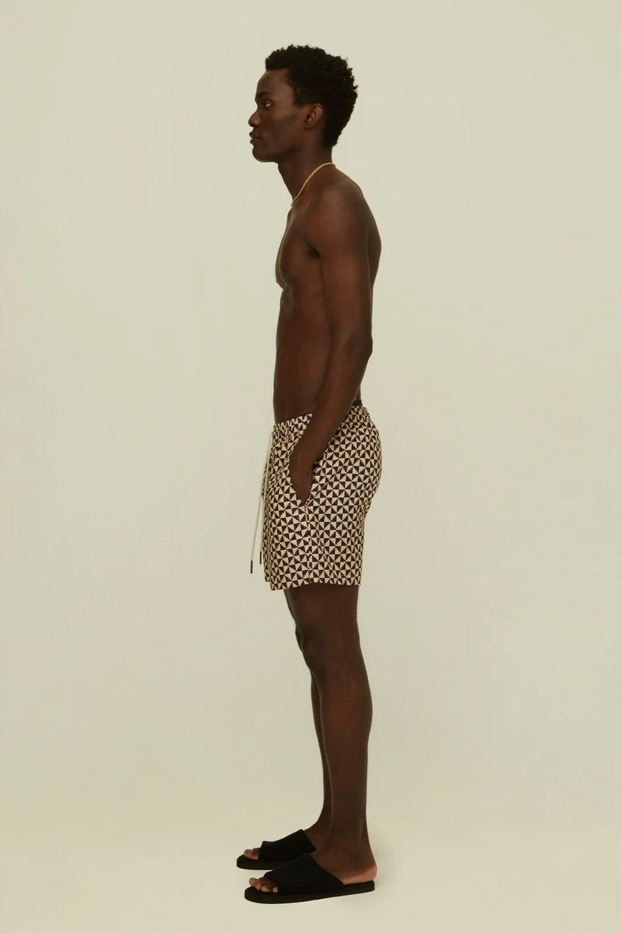 Profile view of a man in swim shorts and slides